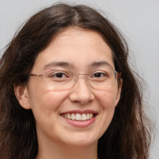 Joyful white adult female with long  brown hair and brown eyes