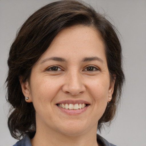 Joyful white adult female with medium  brown hair and brown eyes