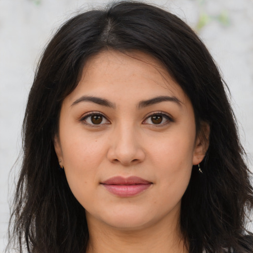 Joyful latino young-adult female with long  brown hair and brown eyes