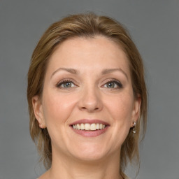 Joyful white adult female with medium  brown hair and grey eyes