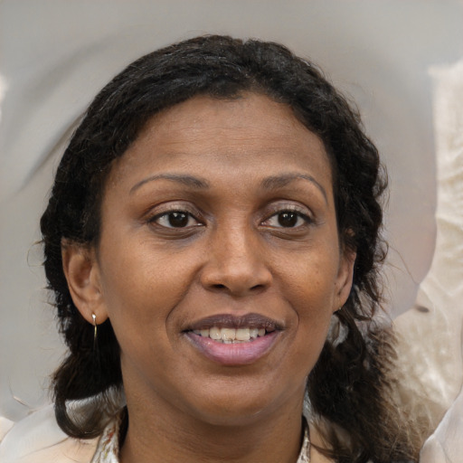 Joyful black adult female with medium  brown hair and brown eyes