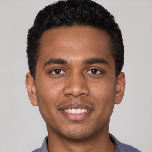 Joyful black young-adult male with short  black hair and brown eyes