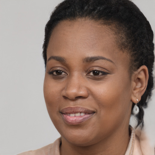Joyful black young-adult female with long  brown hair and brown eyes