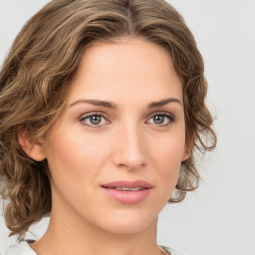 Joyful white young-adult female with medium  brown hair and green eyes