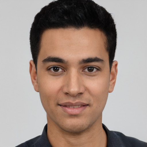 Joyful latino young-adult male with short  black hair and brown eyes