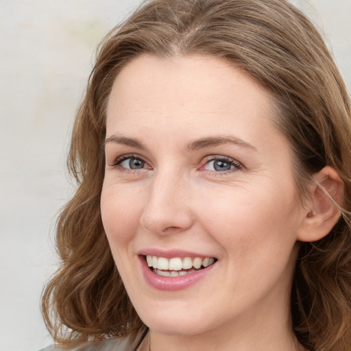 Joyful white young-adult female with long  brown hair and green eyes