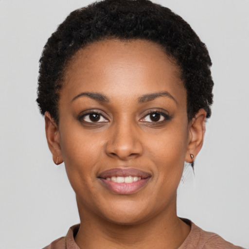 Joyful black young-adult female with short  black hair and brown eyes