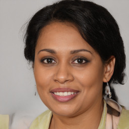 Joyful latino adult female with medium  brown hair and brown eyes