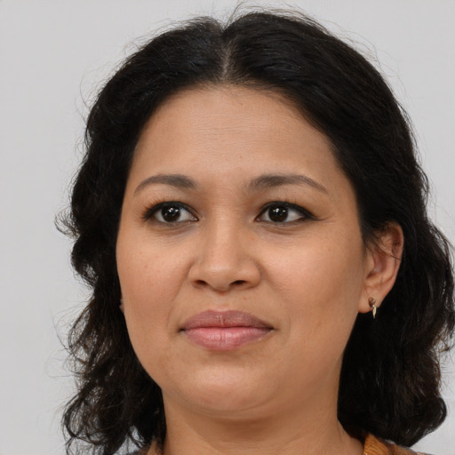 Joyful latino adult female with medium  brown hair and brown eyes