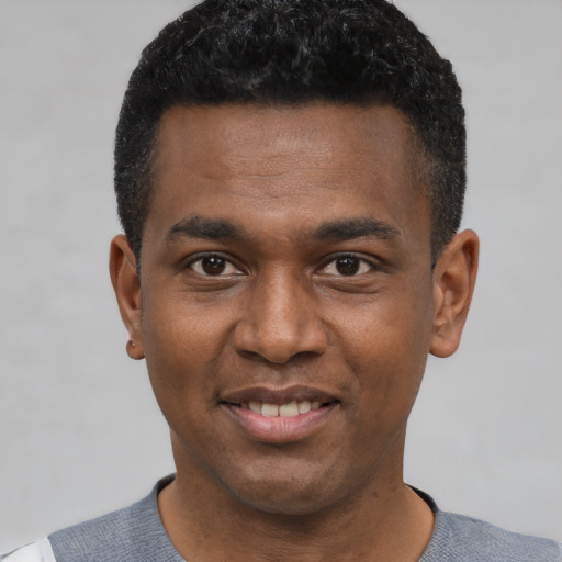 Joyful black young-adult male with short  black hair and brown eyes