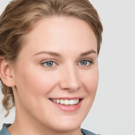 Joyful white young-adult female with medium  brown hair and blue eyes