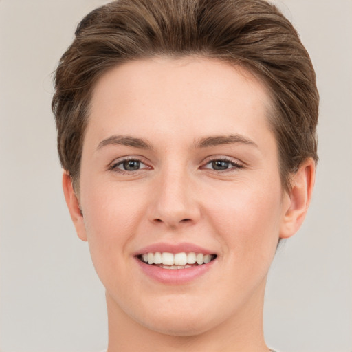 Joyful white young-adult female with short  brown hair and grey eyes