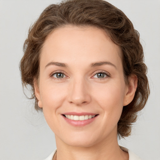 Joyful white young-adult female with medium  brown hair and green eyes