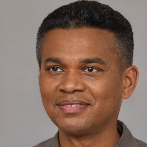 Joyful black adult male with short  black hair and brown eyes