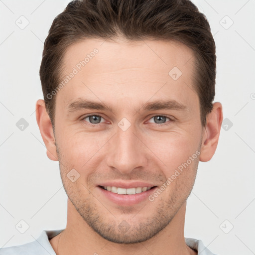 Joyful white young-adult male with short  brown hair and grey eyes