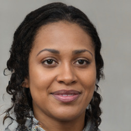 Joyful black adult female with medium  brown hair and brown eyes