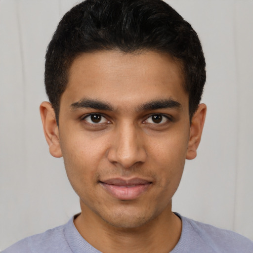 Joyful latino young-adult male with short  brown hair and brown eyes