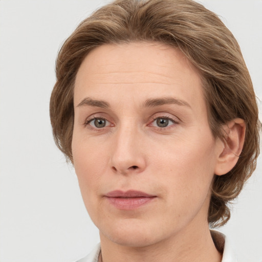 Joyful white adult female with medium  brown hair and grey eyes