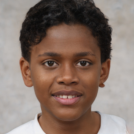 Joyful black child male with short  brown hair and brown eyes