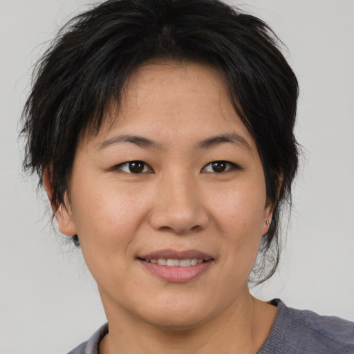 Joyful asian adult female with medium  brown hair and brown eyes