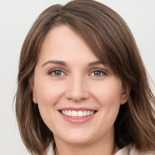 Joyful white young-adult female with medium  brown hair and grey eyes