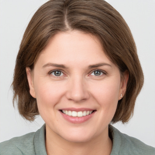 Joyful white young-adult female with medium  brown hair and grey eyes