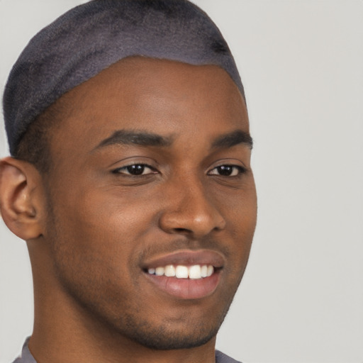 Joyful black young-adult male with short  brown hair and brown eyes