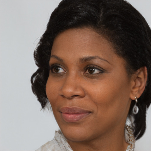 Joyful black adult female with medium  brown hair and brown eyes