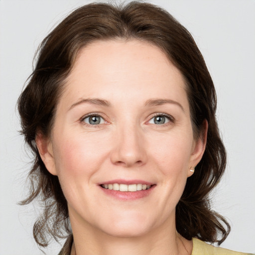 Joyful white adult female with medium  brown hair and green eyes