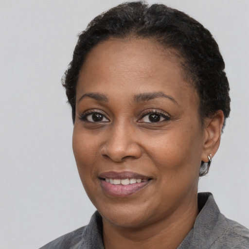 Joyful black adult female with short  black hair and brown eyes