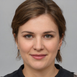 Joyful white young-adult female with medium  brown hair and grey eyes