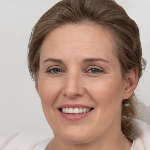 Joyful white adult female with medium  brown hair and brown eyes