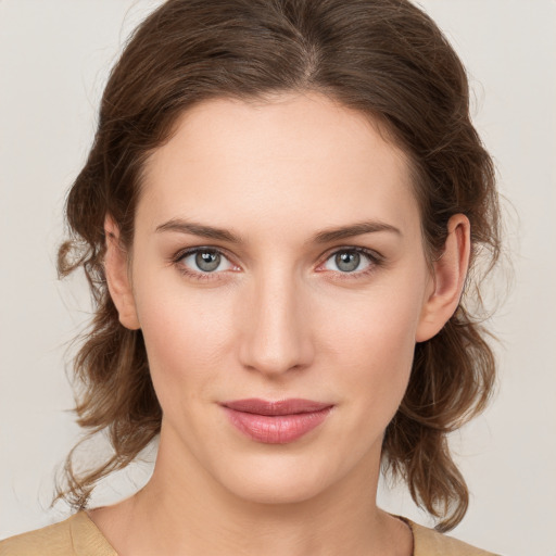 Joyful white young-adult female with medium  brown hair and green eyes