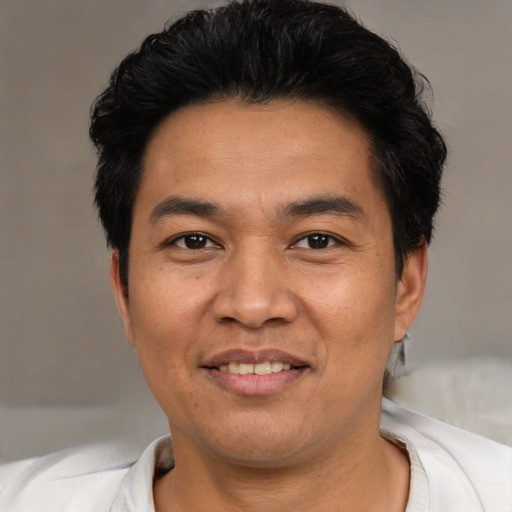 Joyful asian adult male with short  black hair and brown eyes