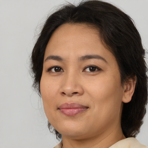 Joyful asian adult female with medium  brown hair and brown eyes