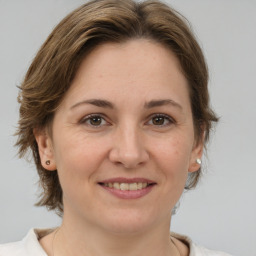 Joyful white adult female with medium  brown hair and brown eyes