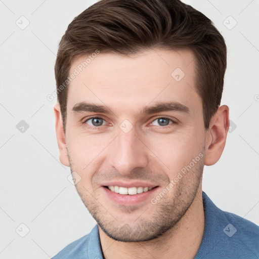 Joyful white young-adult male with short  brown hair and grey eyes