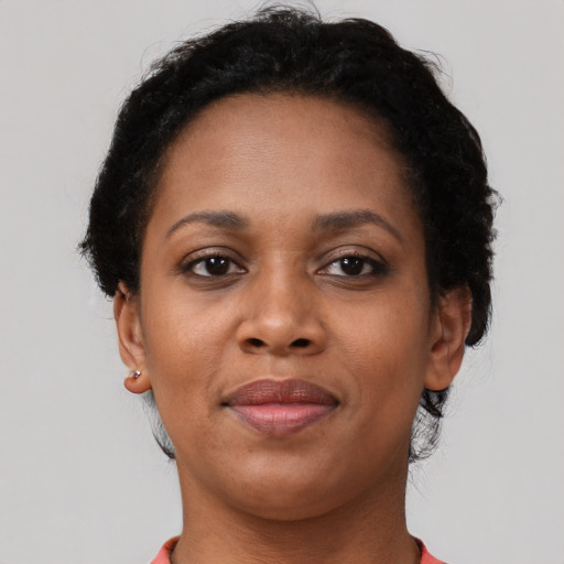 Joyful black adult female with short  brown hair and brown eyes