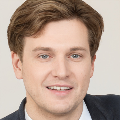 Joyful white young-adult male with short  brown hair and grey eyes