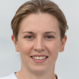 Joyful white young-adult female with short  brown hair and grey eyes