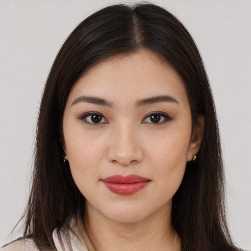 Joyful latino young-adult female with long  brown hair and brown eyes
