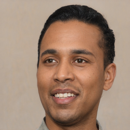 Joyful latino young-adult male with short  black hair and brown eyes