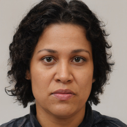 Joyful latino adult female with medium  brown hair and brown eyes