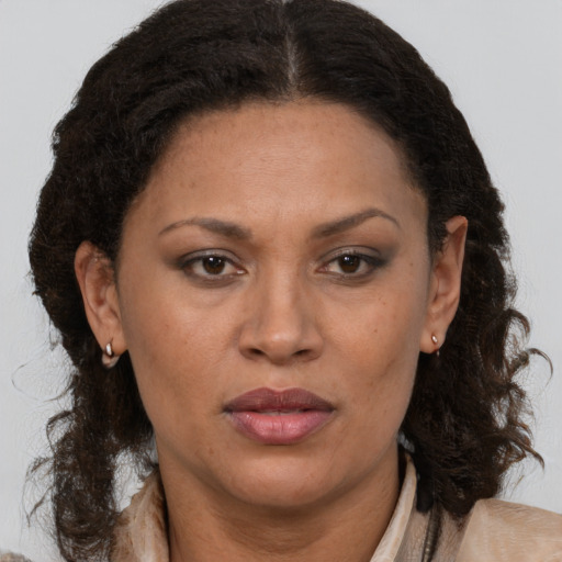 Joyful latino adult female with medium  brown hair and brown eyes