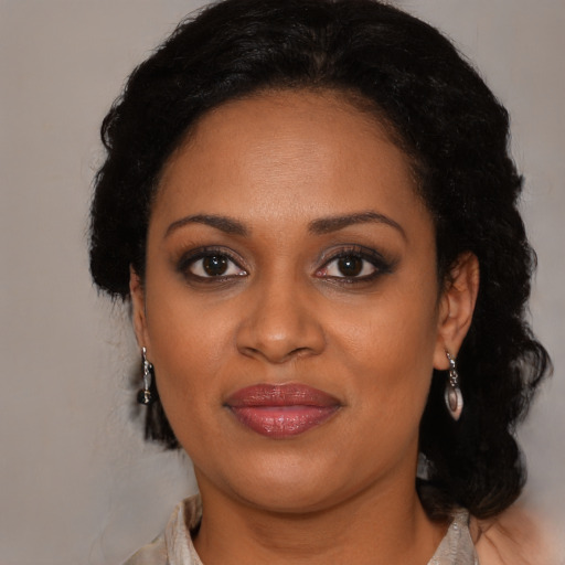 Joyful black adult female with medium  brown hair and brown eyes