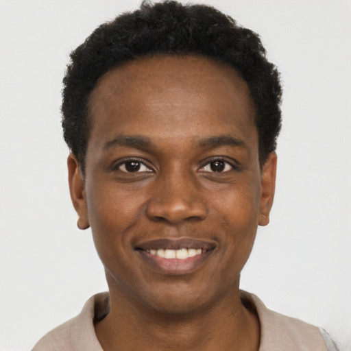 Joyful black young-adult male with short  brown hair and brown eyes