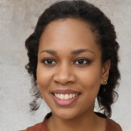 Joyful black young-adult female with long  brown hair and brown eyes