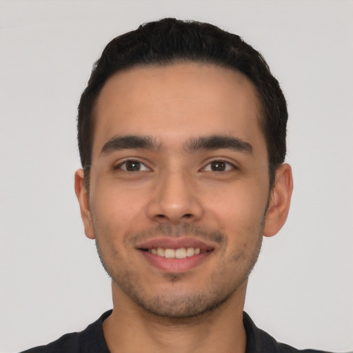 Joyful latino young-adult male with short  black hair and brown eyes