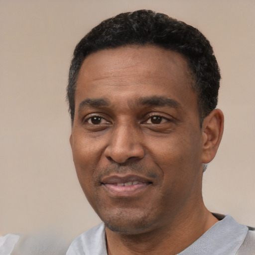 Joyful black adult male with short  black hair and brown eyes