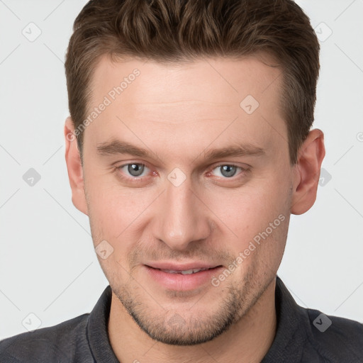 Joyful white young-adult male with short  brown hair and grey eyes